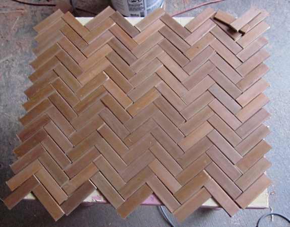 8. Once you have figured out the way you would like your herringbone pattern to go, clear the tabletop, find the center of your tabletop surface and lay the pieces starting from the center