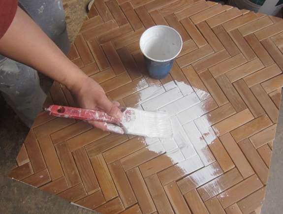 16. Flip table back upright; prime the herringbone top. Let dry, then brush on two coats